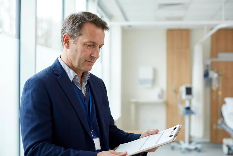 Emergency medicine consultant reviewing a patient chart for a medico-legal report
